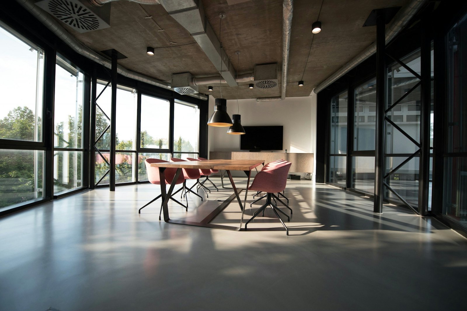 Finished open-plan office with glass-walled meeting rooms and polished concrete floors