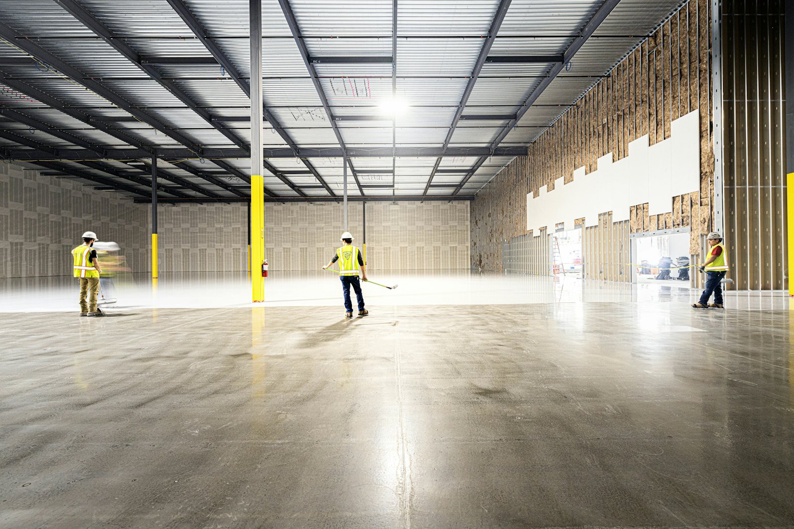 Team inspecting a large, empty industrial warehouse space