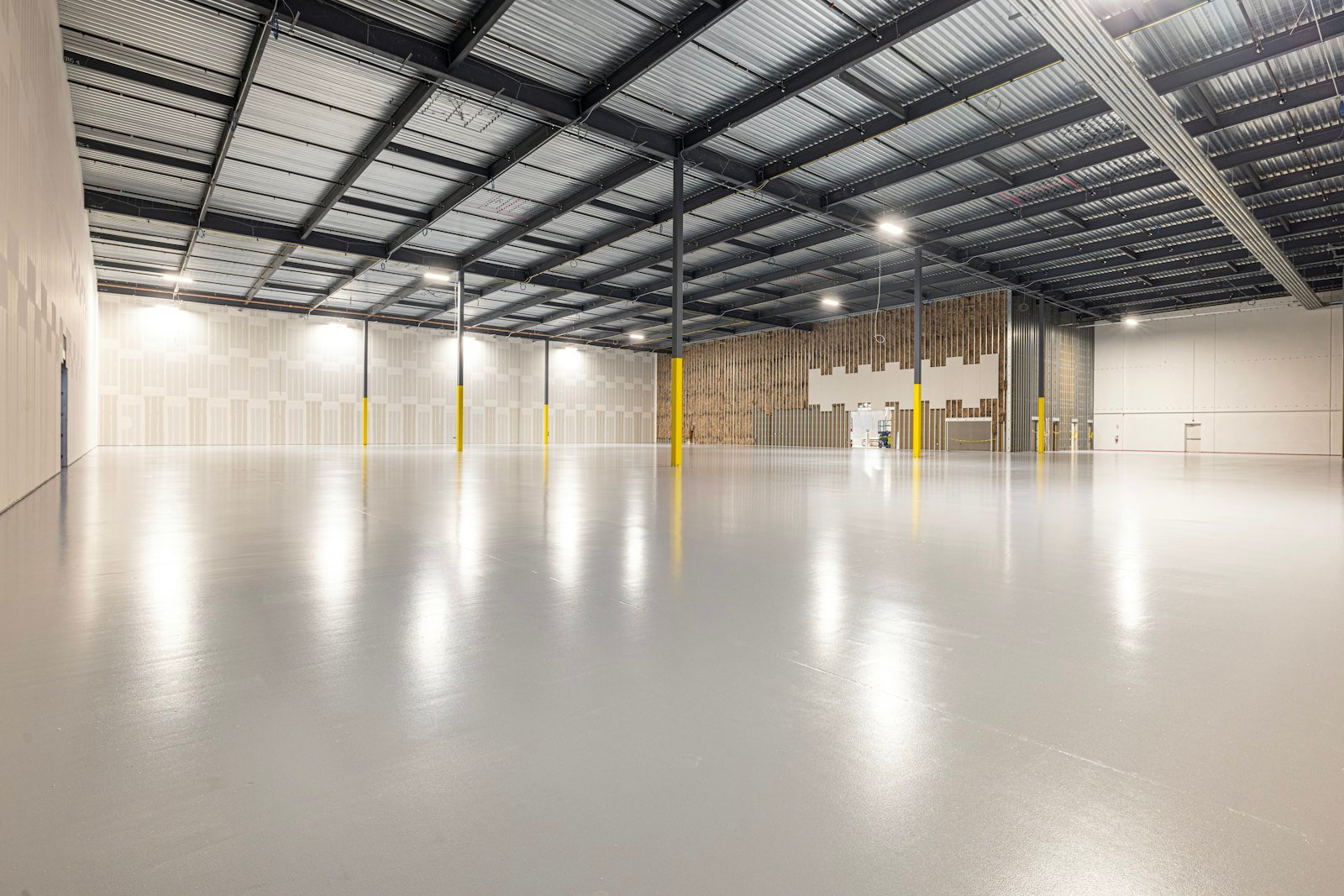 Empty industrial warehouse with high bay lighting and polished concrete floor